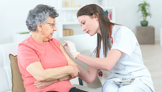 Kvinde giver injektion til patient